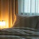 Cozy bedroom setting with soft lamplight, denoting sleep optimization and recovery.